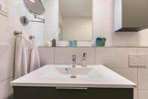 a white bathroom with a sink and a mirror at Hodderup Wohnung 10 in Husby