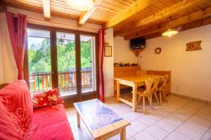 a living room with a red couch and a table at Anémone in Valloire