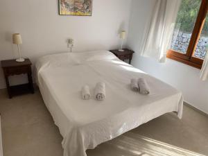 a bedroom with a bed with two pairs of slippers on it at Can Botana 3 in Cala de Sant Vicenc +26 photos