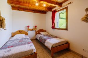 two beds in a room with a window at Anémone in Valloire