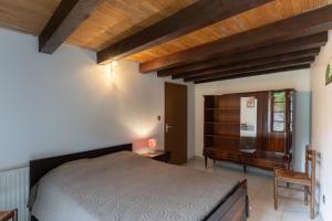 a bedroom with a bed and a wooden ceiling at Les Sources Gîte La Grange in Chambonas