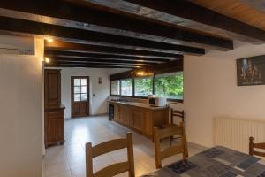 a kitchen with wooden ceilings and a table with chairs at Les Sources Gîte La Grange in Chambonas +17 photos