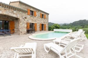 a villa with a swimming pool and lounge chairs at Les Sources Gîte La Grange in Chambonas