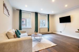 a living room with a couch and a flat screen tv at Altstadt-Oase 2 in Cottbus +13 photos