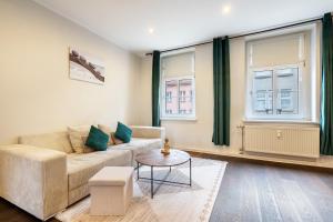 a living room with a couch and two windows at Altstadt-Oase 2 in Cottbus