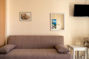 a living room with a couch and a mirror at Nontas Home 21 in Kalamitsi