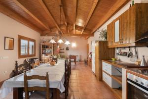 a kitchen and dining room with a table and chairs at Cal Torrentí in Caserras