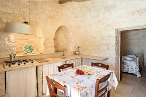 a kitchen with a table and a sink and a stove at Trullo Pesco in Martina Franca