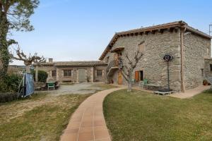 a large stone building with a walkway in front of it at Cal Torrentí in Caserras