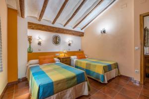 two beds in a room with orange and blue at Romero in Hinojares