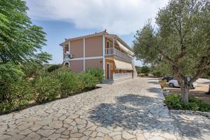 a house with a stone driveway in front of it at Dimaras Apartments Zakynthos in Vasilikos