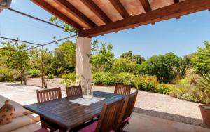 a wooden table and chairs on a patio at Es Romagueral in Artá