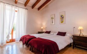 a bedroom with a large bed with a red blanket at Es Romagueral in Artá +18 photos