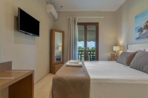 a bedroom with a large bed and a television at Dimaras Apartments Zakynthos in Vasilikos