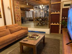 a living room with a couch and a table with chess at casa glamping in Lunahuaná