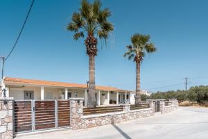 a house with two palm trees in front of it at Absinthia Fanes in Rhodes Town