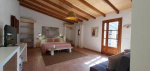 a bedroom with a bed and a tv in a room at Casa s’Hort - Can Rita in Llombarts