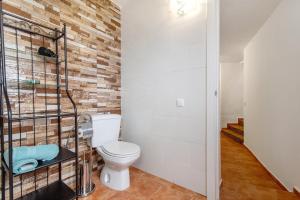 a bathroom with a toilet and a brick wall at Casa Verol B in Moya +16 photos