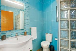 a blue bathroom with a sink and a toilet at The Wave House - Two Bedroom Flat in Jardim do Mar +35 photos
