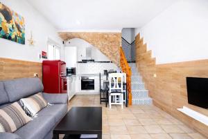 a living room with a couch and a kitchen at CASA ADELA - Playa 2 min - Aire Acondicionado - WIFI - Parking cercano in Barbate