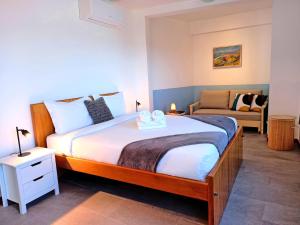 a bedroom with a large bed and a couch at The Wave House - Two Bedroom Flat in Jardim do Mar