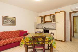 a living room with a table and a couch at Il Girasole - Corbezzolo in Venturina Terme