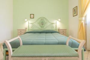a bedroom with a blue bed with a bench on it at Il Girasole - Corbezzolo in Venturina Terme +25 photos