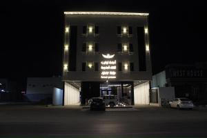 a building with a truck parked in front of it at night at أجنحة توليب للشقق المخدومة in Hafr Al-Batin