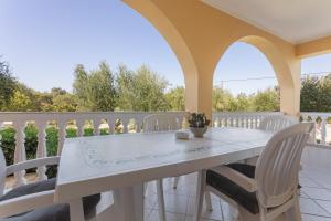 a white table and chairs on a balcony at Dimaras Apartments Zakynthos in Vasilikos