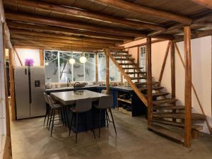 a kitchen with a staircase and a table with stools at casa glamping in Lunahuaná