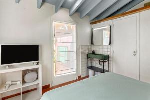 a bedroom with a bed and a tv and a window at Chambres d'hôtes - La Moustelle in La Croix-Valmer +49 photos