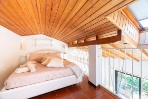 a bed in a room with a wooden ceiling at Begna Kiddie Paradise Poolside Retreat in Porlezza