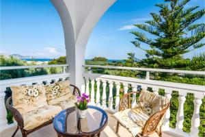 a balcony with chairs and a table and a palm tree at Tamar Apartments, Laganas in Laganas