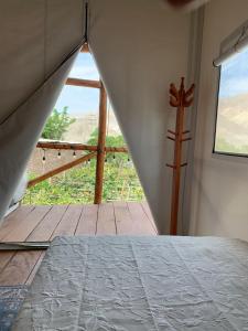 a bedroom with a bed and a view of a balcony at casa glamping in Lunahuaná +22 photos