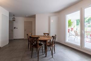 a dining room with a wooden table and chairs at La Providence in Annecy