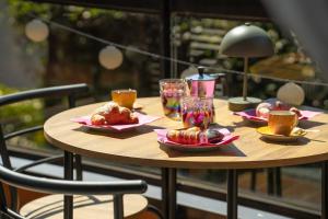 a wooden table with plates of food and glasses on it at Begna Kiddie Paradise Poolside Retreat in Porlezza +25 photos