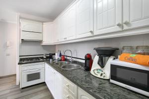 a kitchen with white cabinets and a counter top at Las Teresitas Beach Apartment in San Andrés
