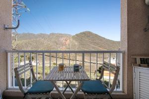 a table and chairs on a balcony with a view of a mountain at Las Teresitas Beach Apartment in San Andrés