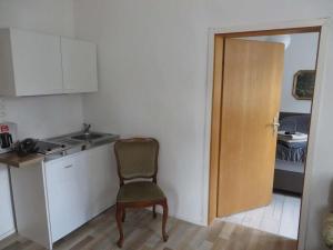 a kitchen with a chair and a sink and a door at Historischer Marktplatz in Spangenberg