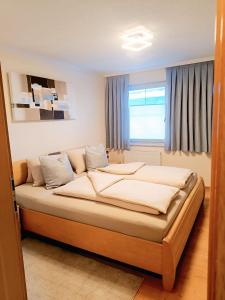 a bedroom with a large bed in front of a window at Apart Bergtraum Ried - Typ 2 in Ried im Oberinntal