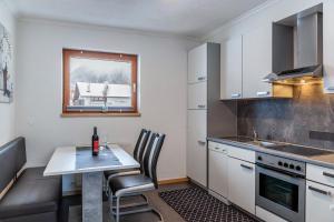 a kitchen with a table with a bottle of wine on it at Apart Bergtraum Ried - Typ 2 in Ried im Oberinntal