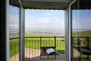 a view of the ocean from a screened in porch at Ferienwohnung Watt'nblick in Langeneß