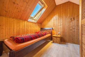 a bed in a room with wooden walls and a window at Ferienwohnungen zur Reuse in Mardorf