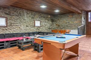 a pool table in a room with a stone wall at La Posada Del Chano in Cerecedo de Besullo