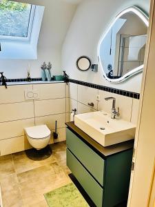 a bathroom with a sink and a toilet and a mirror at Ferienwohnung Stern in Goslar