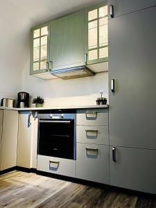 a kitchen with white cabinets and a black oven at Ferienwohnung Stern in Goslar +17 photos