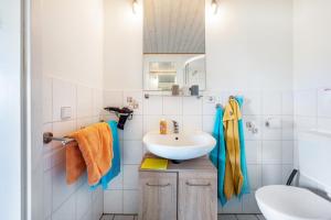 a white bathroom with a sink and a mirror at Fluss aufwärts in Schülp +18 photos