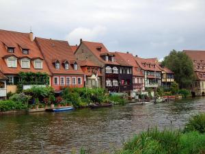 a group of houses next to a river with boats at Ferienwohnungen Sonnenblumenhaus in Bamberg