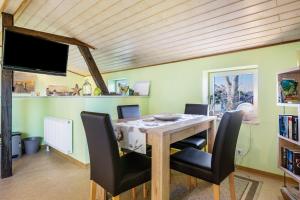 a dining room with a table with chairs and a tv at Fluss aufwärts in Schülp