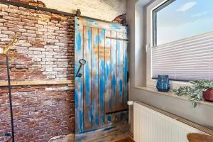 a wooden door in a room with a brick wall at Happy Place Indu Style in Korbach +31 photos